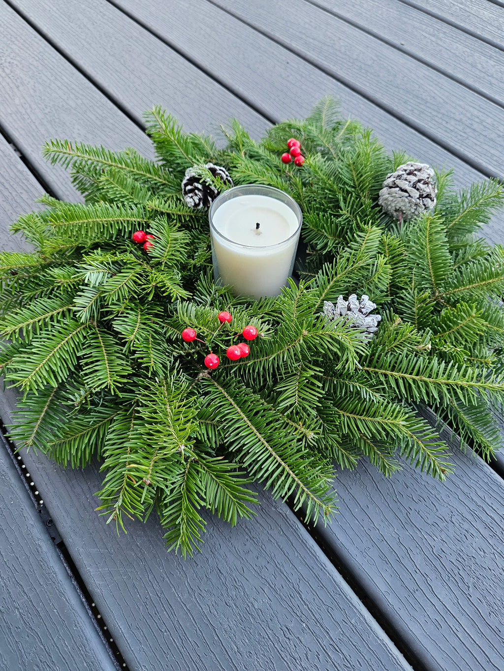 Decorative wreath with a candle on a wooden surface