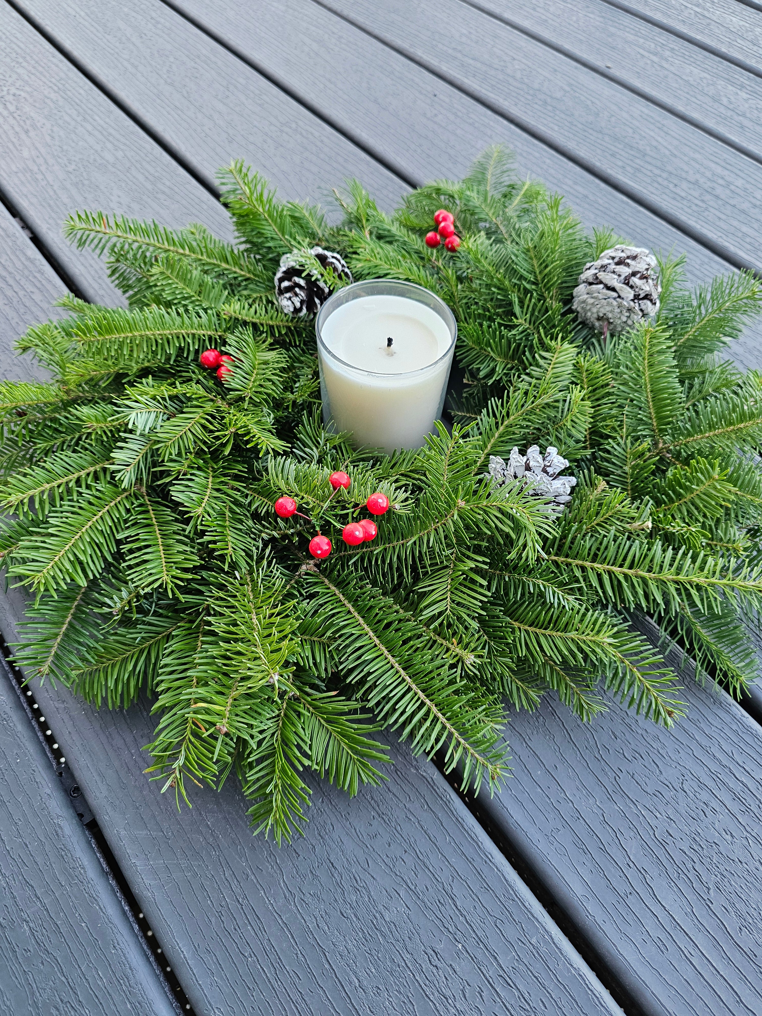 Decorative wreath with a candle on a wooden surface