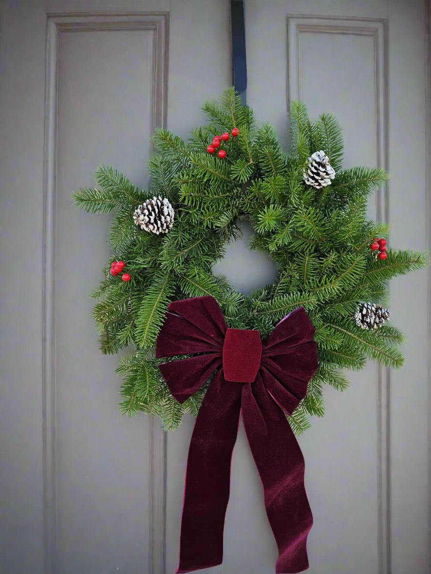 Christmas wreath with a red bow on a door