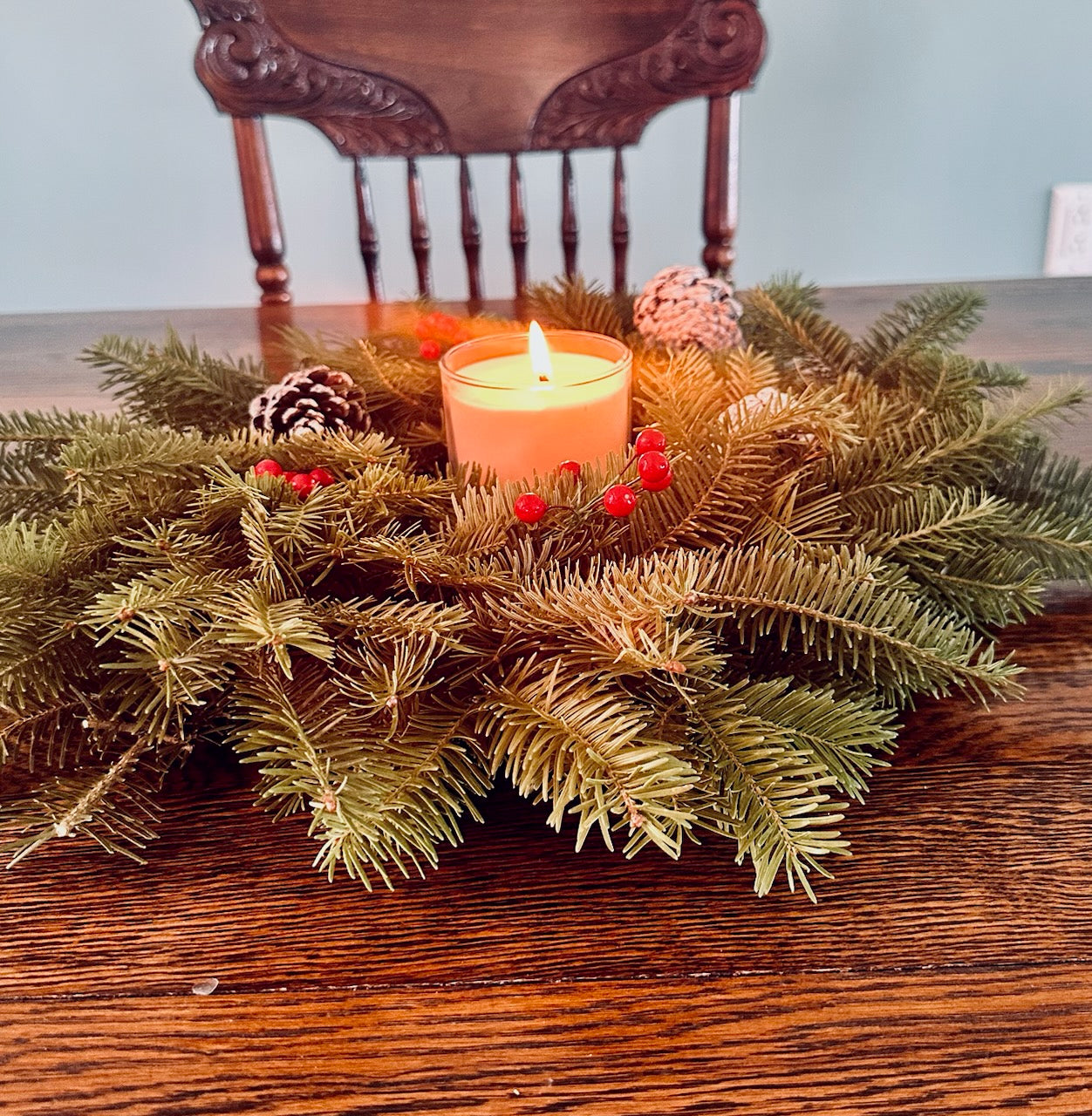 Decorative wreath with a candle on a wooden table